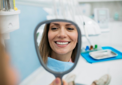 A woman smiles into the mirror after a Teeth Cleaning in East Peoria IL