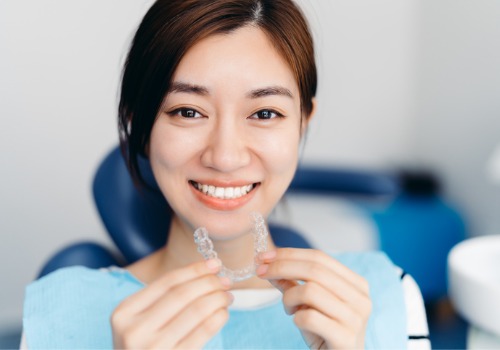 A woman smiles before putting in Invisalign in East Peoria IL