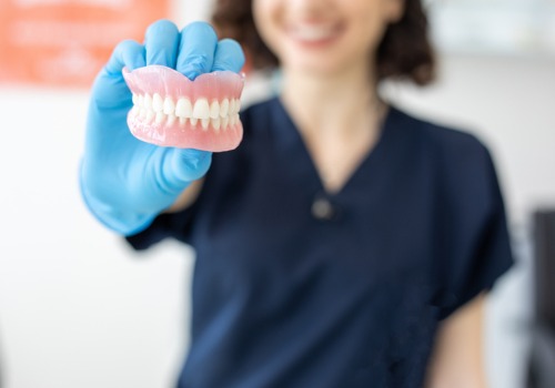 A dental hygienist holds up Dentures in East Peoria IL