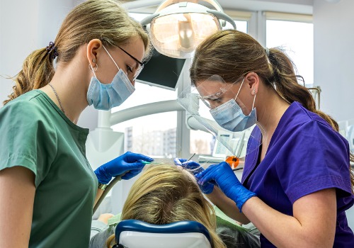 A dental team performs services on a patient.