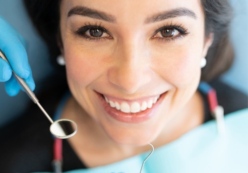 A dentist is seen matching tooth colors on a patient. River City Family Dentistry is a Dental Office in Peoria IL.