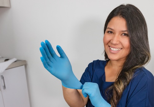A dental professional is seen donning her gloves. River City Family Dentistry offers family dental care.